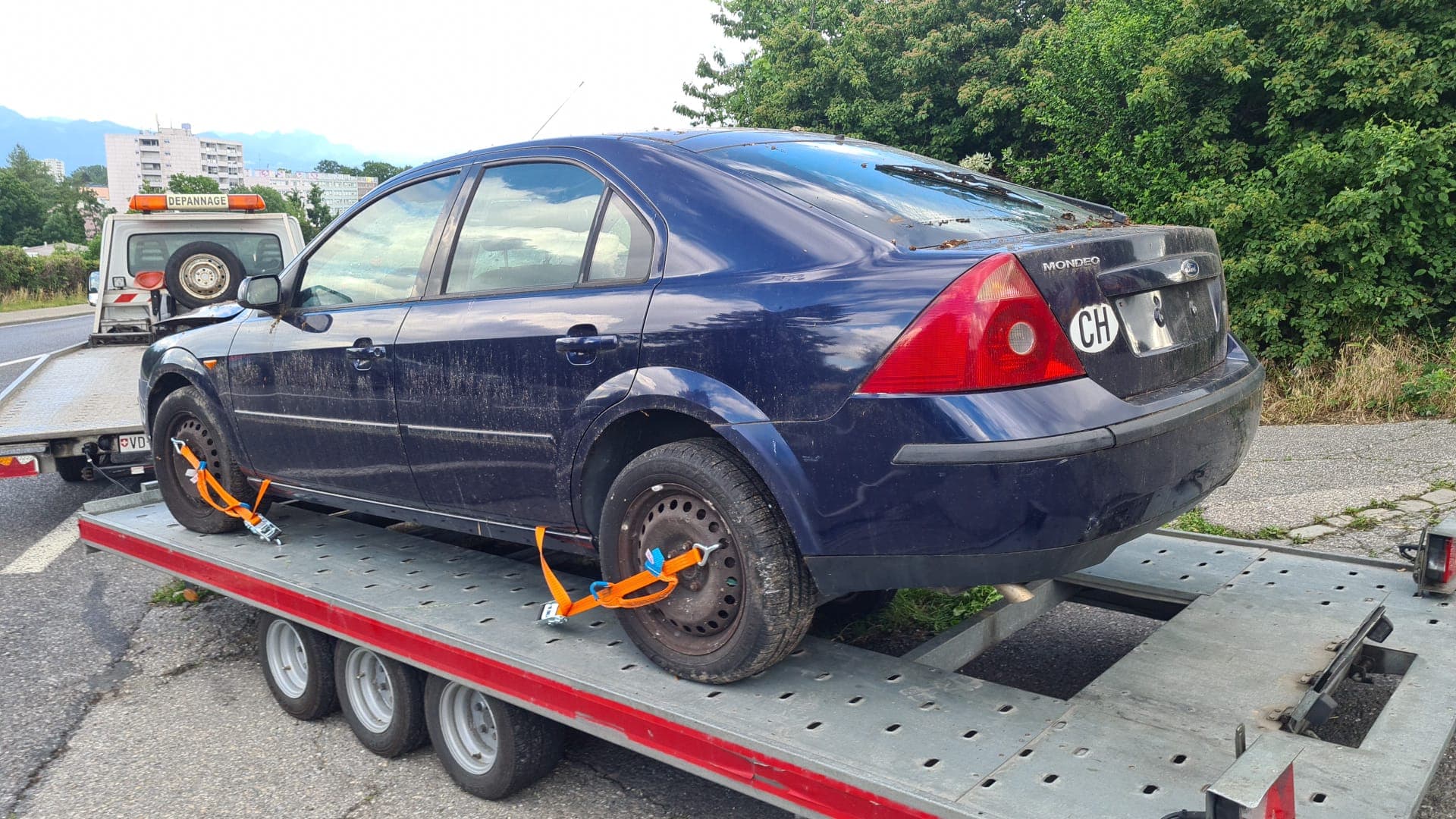 Véhicule sanglé sur le plateau d'une dépanneuse Daly Transport