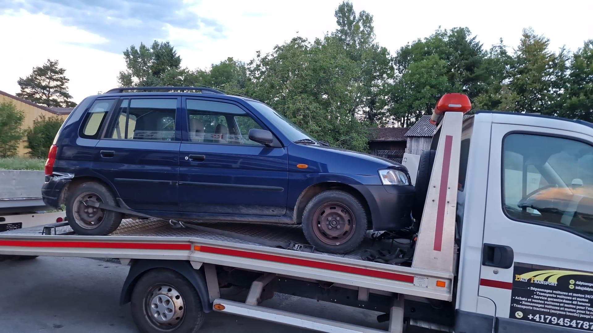 Véhicule sanglé sur le plateau d'une dépanneuse Daly Transport