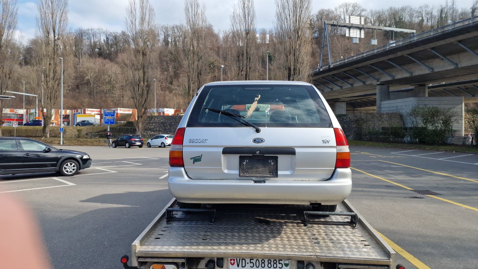 Véhicule sanglé sur le plateau d'une dépanneuse Daly Transport