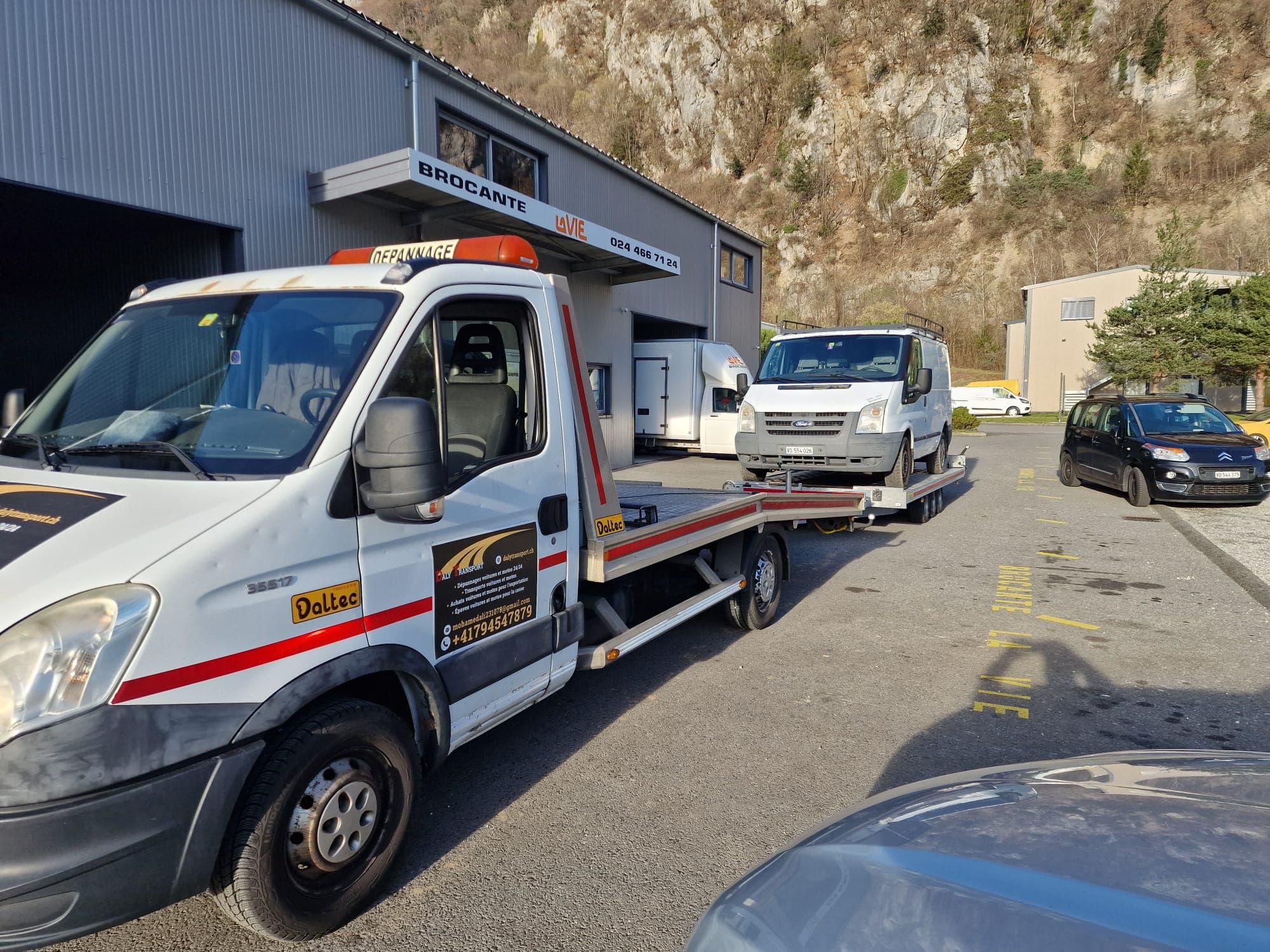 Véhicule sanglé sur le plateau d'une dépanneuse Daly Transport