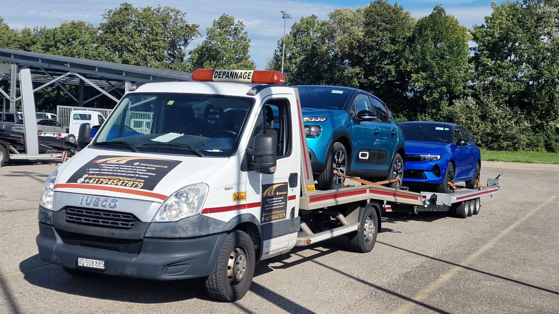 Véhicule sanglé sur le plateau d'une dépanneuse Daly Transport